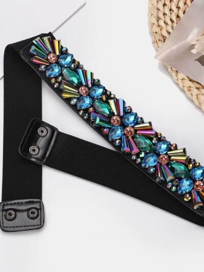 unzipped colorful belt with crystals lying on a white table
