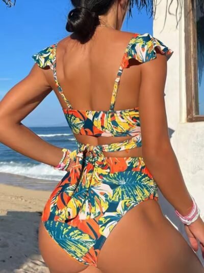 woman turned to her back wearing colorful bikini with jungle print, the beach in the background