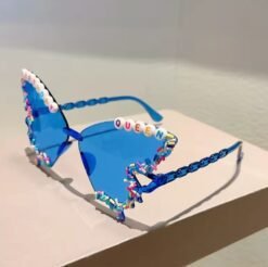 side view of blue variation of colorful Birthday sunglasses on a beige surface