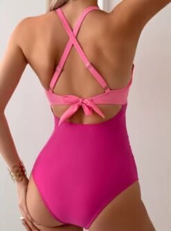 woman turned to her back wearing colorful cross back one piece swimsuit