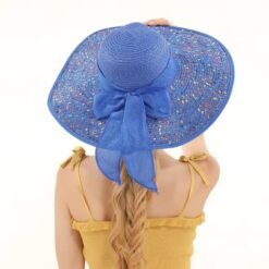 woman turned to her back wearing colorful hat with a large brim and a yellow top