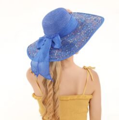 woman turned to her back wearing colorful hat with a large brim and a muted yellow blouse