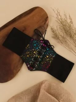 colorful lace up belt lying on a beige table, brown wood next to it