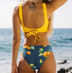 woman turned to her back wearing colorful lemon bikini on the beach