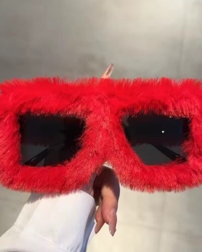 woman holding red variation of colorful plush sunglasses