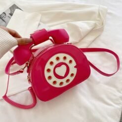 woman holding hot pink colorful telephone bag above the white bedsheets