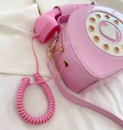 side view of pink colorful telephone bag on the white bed
