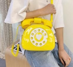 woman wearing yellow colorful telephone bag, white shirt and jeans