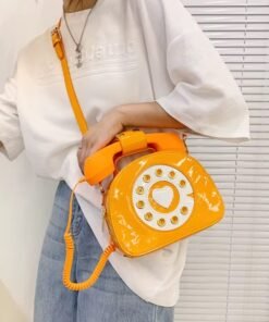 woman wearing orange colorful telephone bag, white shirt and jeans