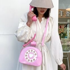 woman wearing a white dress, grey hat and holding pink colorful telephone bag