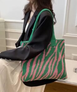 woman wearing green and pink variation of colorful tote bag, black jacket and white skirt