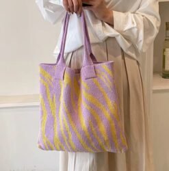woman wearing beige pans, white button shirt and holding yellow and purple variation of colorful tote bag