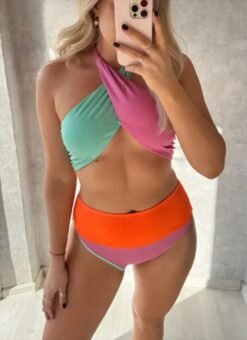 woman with blonde hair wearing criss-cross colorful bikini and holding a phone