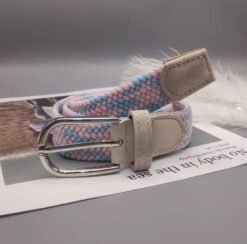 folded pastel colorful belt lying on a white newspaper, grey background