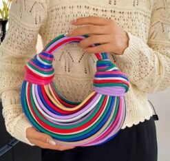 woman wearing a white sweater and holding retro colorful bag