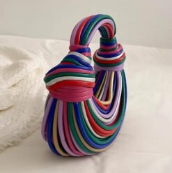 side view of retro colorful bag lying on the white bed