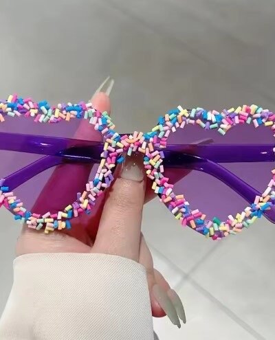 woman holding purple variation of sunglasses with colored frames