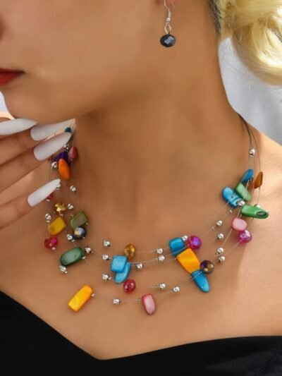 woman wearing colorful crystal jewelry set, she has red lips and white-painted nails