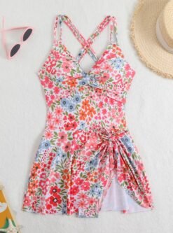 front view of colorful one piece swimsuit with a skirt on the white background, sunglasses and a beige hat next to it