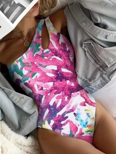 woman wearing colorful one shoulder swimsuit and a denim coat