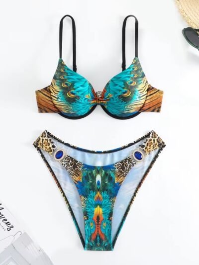 colorful peacock print bikini on the white background, a magazine and sunglasses next to it