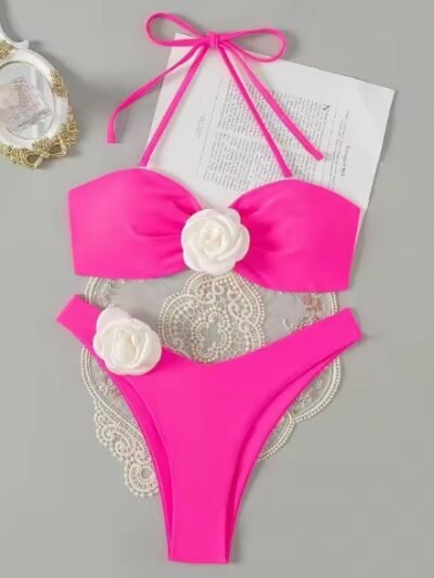 pink variation of romantic colorful bikini lying on the grey table, piece of paper under it