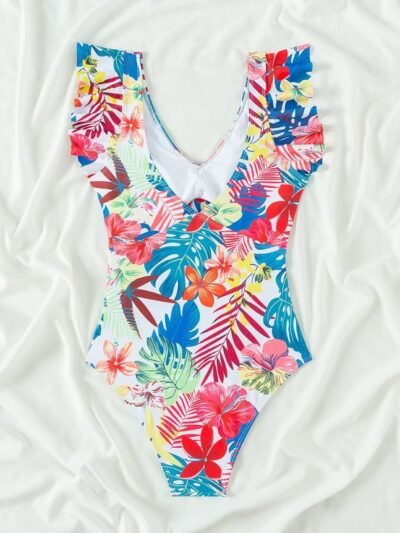 back view of tropical colorful one piece swimsuit on a white blanket