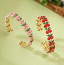 pink and red variations of cherry bracelet standing on a green surface