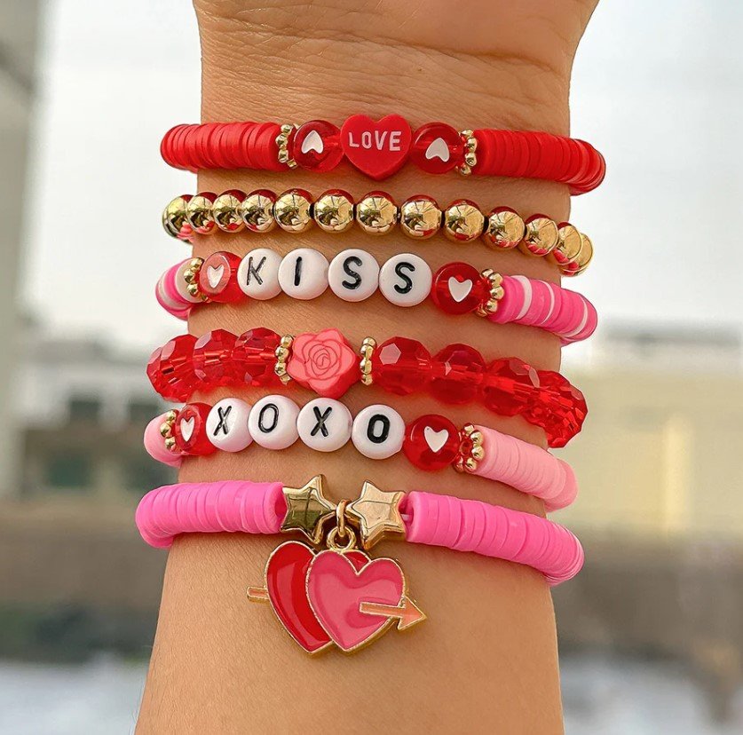 woman wearing Valentine's day bracelets, city in the background