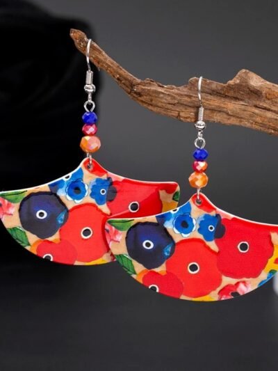 big colorful earrings hung on a branch of a small tree