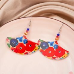 big colorful earrings lying on a beige material