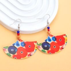 big colorful earrings placed on a ceramic white plate