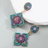 Bohemian colorful earrings placed on grey and white surface
