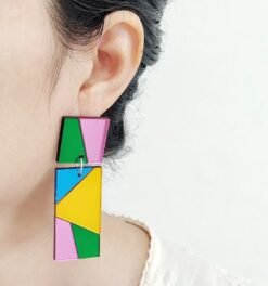 woman with black hair wearing color block earrings
