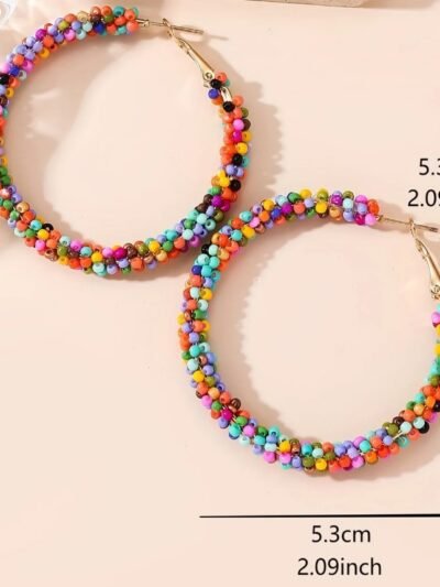 colored hoop earrings on the beige surface, their size provided