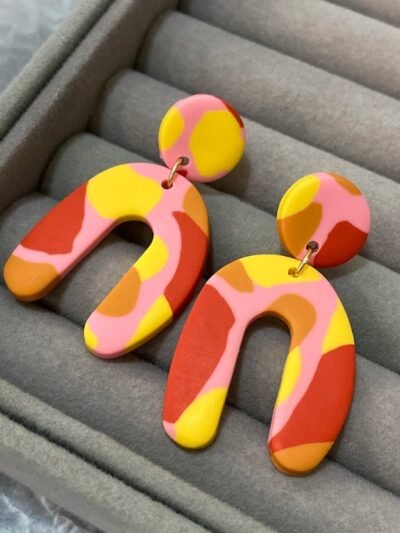 colorful arched earrings in a grey jewelry box