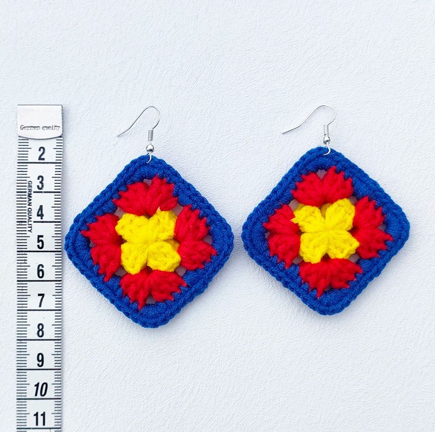 size of colorful crochet earrings demonstrated with a measuring tape