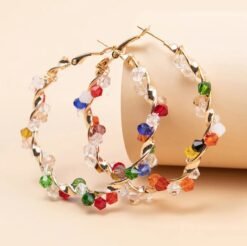 colorful crystal earrings leaning on a beige pillow