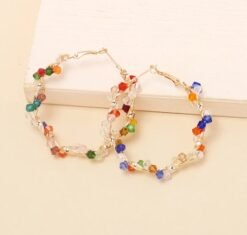 colorful crystal earrings on the beige background