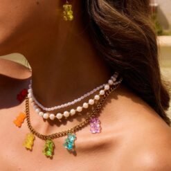 woman wearing colorful gummy bear necklace, pearl necklace and gummy bear earrings