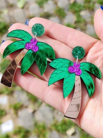 woman holding colorful palm earrings
