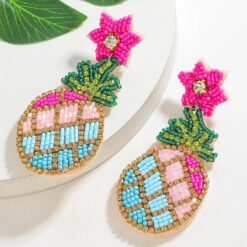 side view of colorful pineapple earrings on the white table