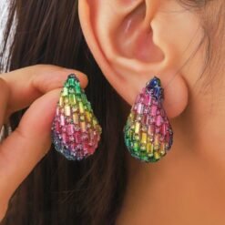 woman with dark brown hair wearing colorful waterdrop earrings