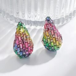 colorful waterdrop earrings next to a glass of water