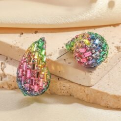 front and back view of colorful waterdrop earrings on the beige bricks