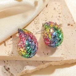 side view of colorful waterdrop earrings on the beige bricks