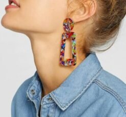 woman wearing large colorful earrings and blue shirt