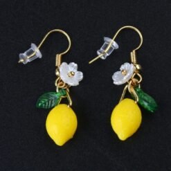 front view of lemon earrings on the black background