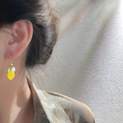 woman with black hair wearing lemon earrings