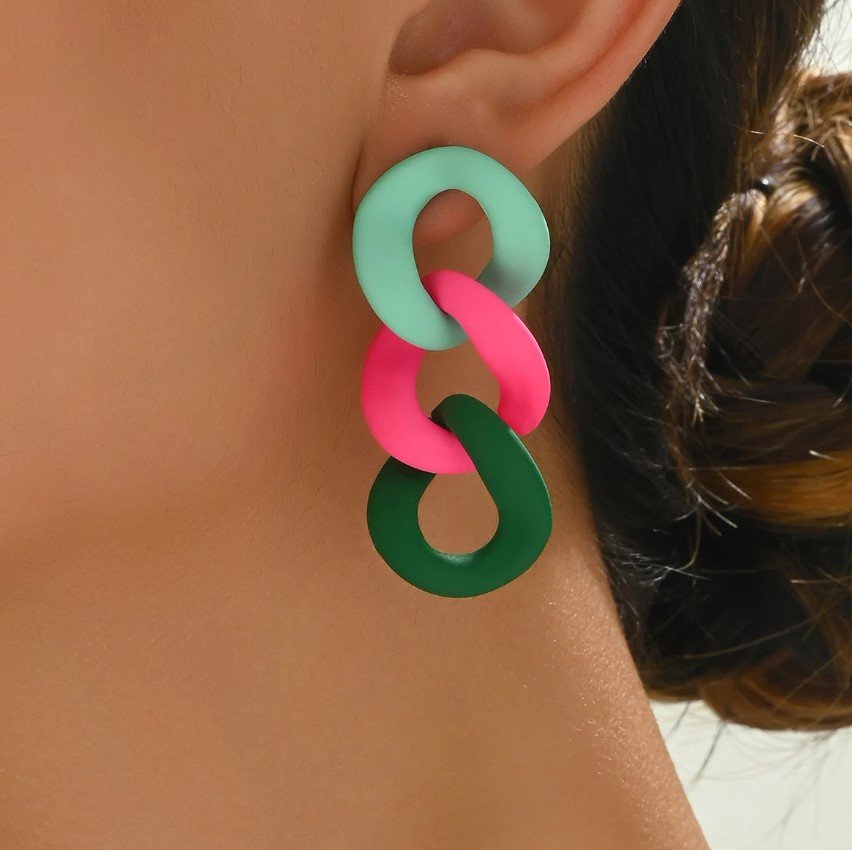 woman with brown hair wearing vintage colorful earrings